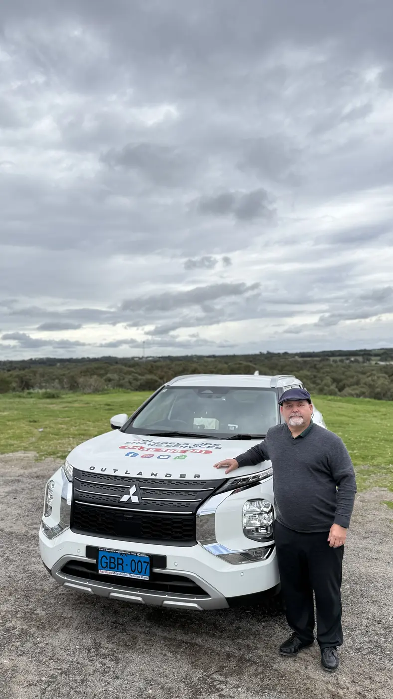 Garry with his white Mitsubishi Outlander, the car used for group day trips